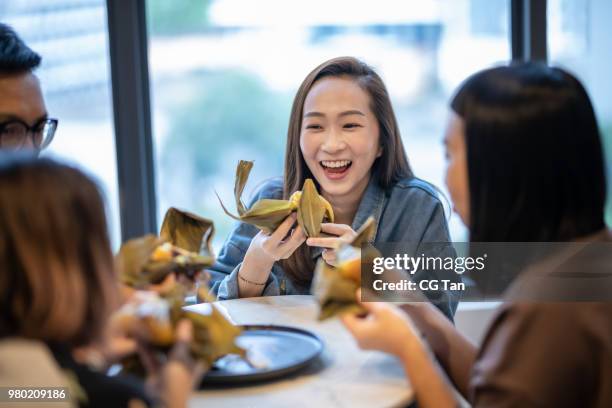 enjoying and eating 'zongzi' or 'bakcang', 'bacang' a chinese traditional food - zongzi stock pictures, royalty-free photos & images