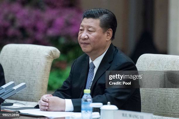China's President Xi Jinping listens Papua New Guinea Prime Minister Peter O'Neill during a meeting at the Diaoyutai State Guesthouse on June 21...