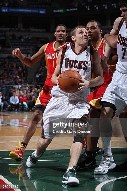 Luke Ridnour of the Milwaukee Bucks drives past Chuck Hayes of the Houston Rockets during the game on February 17, 2010 at the Bradley Center in...