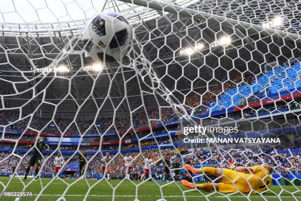 Australia's midfielder Mile Jedinak scores from the penalty spot for Australia's first goal to equalise 1-1 past Denmark's goalkeeper Kasper...