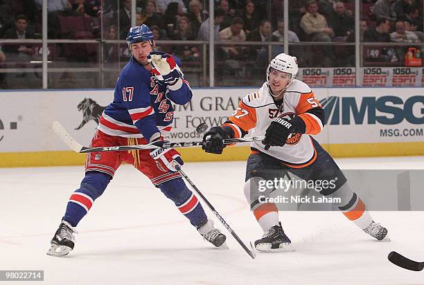 Blake Comeau of the New York Islanders shoots the puck next to Brandon Dubinsky of the New York Rangers at Madison Square Garden on March 24, 2010 in...
