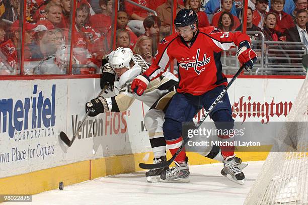 Mike Green of the Washington Capitals goes after a loose puck during an NHL hockey game against Rusian Fedotenko of the Pittsburgh Penguins on March...
