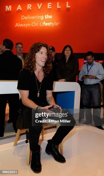 Olympic gold medalist snowboarder Shaun White plays the "Shaun White Snowboarding" video game on an Xbox at the Marvell booth at the International...