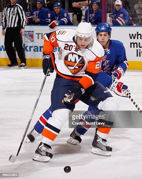 Sean Bergenheim of the New York Islanders skates for the puck under pressure by Dan Girardi of the New York Rangers in the first period on March 24,...