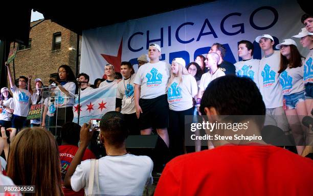 As a young woman speaks from a lectern, March For Our Lives student gun control activists stand on stage during the annual End of the School Year...