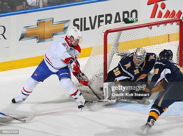 Ryan Miller and Tim Connolly of the Buffalo Sabres defend on a backhand shot by Marc-Andre Bergeron of the Montreal Canadiens at HSBC Arena on March...