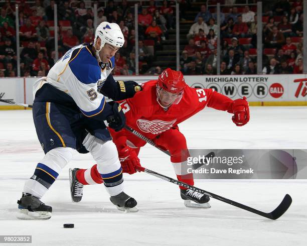 Barret Jackman of the St. Louis Blues and Pavel Datsyuk of the Detroit Red Wings battle for the loose puck during an NHL game at Joe Louis Arena on...