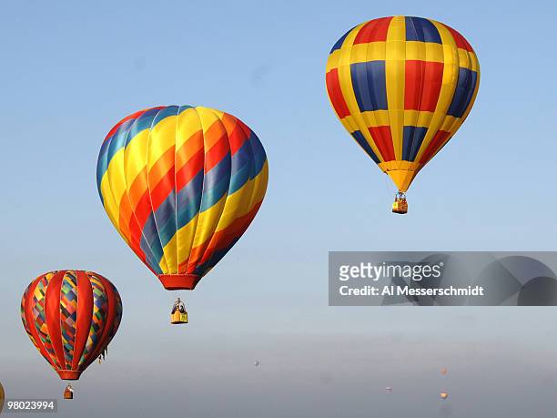 Hot air balloons fly overhead during a morning ascent at the Albuquerque International Balloon Fiesta in Albuquerque, New Mexico on October 8, 2005.