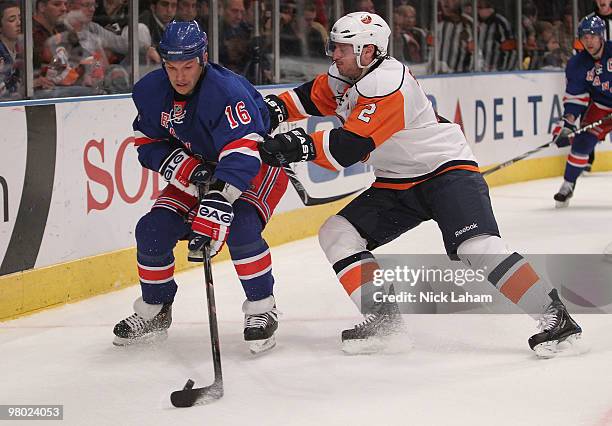 Sean Avery of the New York Rangers skates with the puck in front of Mark Streit of the New York Islanders at Madison Square Garden on March 24, 2010...