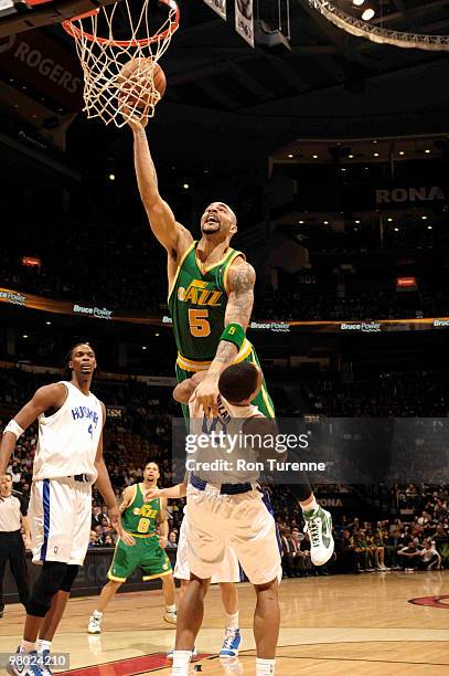 Carlos Boozer of the Utah Jazz drives through the lane and tries the finger-roll over DeMar DeRozan of the Toronto Raptors during a game on March 24,...