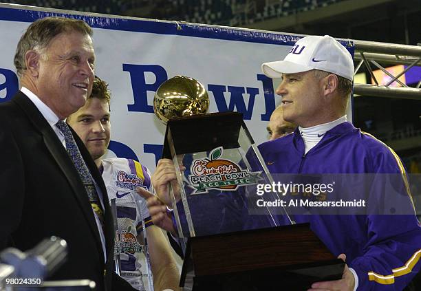Coach Les Miles holds the championship trophy after defeating the University of Miami in the 2005 Chick-fil-A Peach Bowl at the Georgia Dome in...