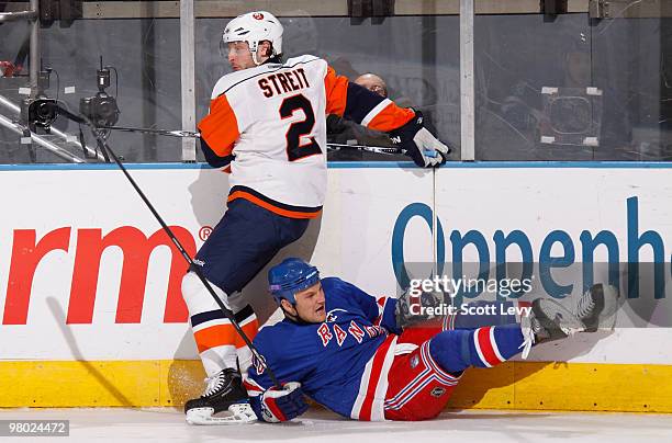 Sean Avery of the New York Rangers is checked along the boards by Mark Streit of the New York Islanders in the second period on March 24, 2010 at...