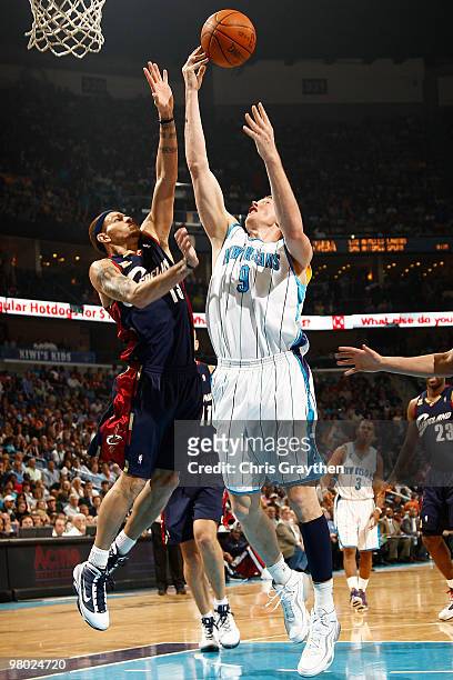 Darius Songaila of the New Orleans Hornets shoots the ball over Delonte West of the Cleveland Cavaliers at the New Orleans Arena on March 24, 2010 in...