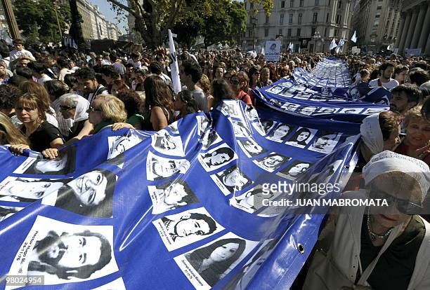 Members of the human rights organization Madres de Plaza de Mayo Linea Fundadora, and other demonstrators, carry a large banner with the portraits of...