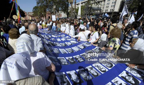 Members of the human rights organization Madres de Plaza de Mayo Linea Fundadora, and other demonstrators, carry a large banner with the portraits of...