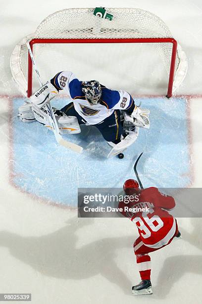 Ty Conklin of the St. Louis Blues makes a save on a shot by Tomas Holmstrom of the Detroit Red Wings during an NHL game at Joe Louis Arena on March...