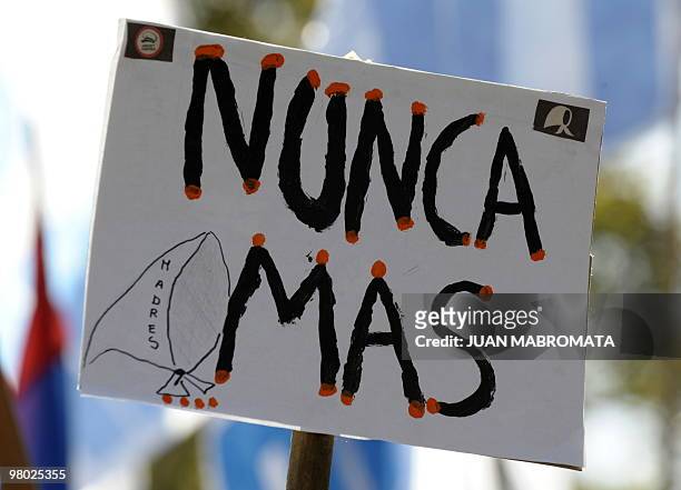 Picture of a poster reading "Never again" and with the headscarf logo of the human rights organization Madres de Plaza de Mayo, taken during a...