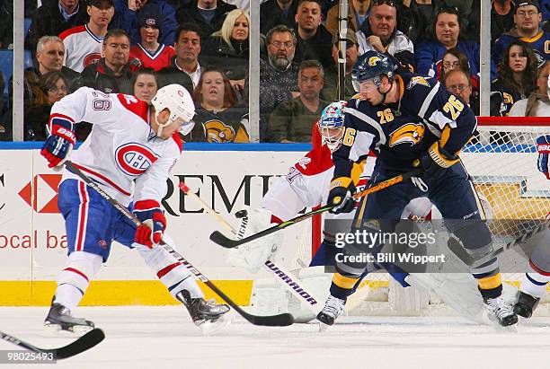 Thomas Vanek of the Buffalo Sabres tries to deflect the puck in the net in front of goaltender Carey Price and Josh Gorges of the Montreal Canadiens...