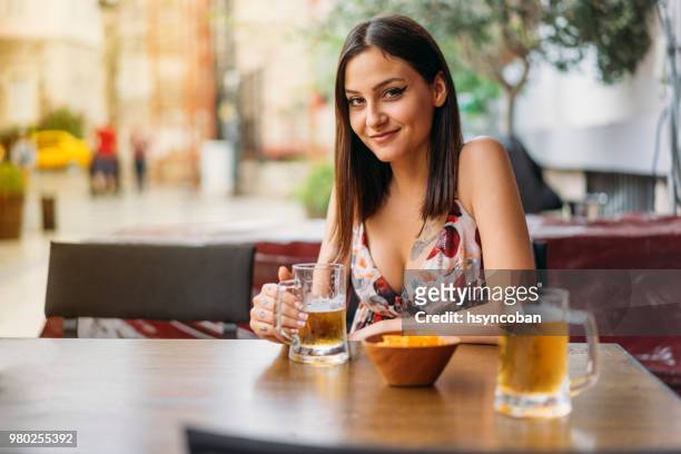 mujer joven bebiendo cerveza - womens draft fotografías e imágenes de stock
