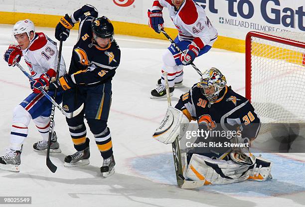 Ryan Miller of the Buffalo Sabres makes a save as Toni Lydman of the Sabres defends on Michael Cammellari of the Montreal Canadiens at HSBC Arena on...