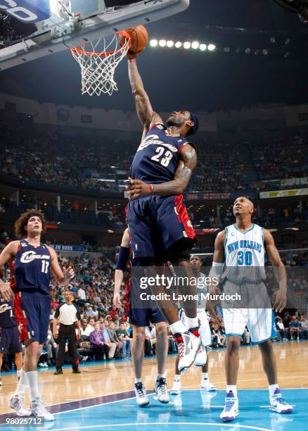 LeBron James of the Cleveland Cavaliers shoots over teammate Anderson Varejao as well as David West of the New Orleans Hornets on March 24, 2010 at...