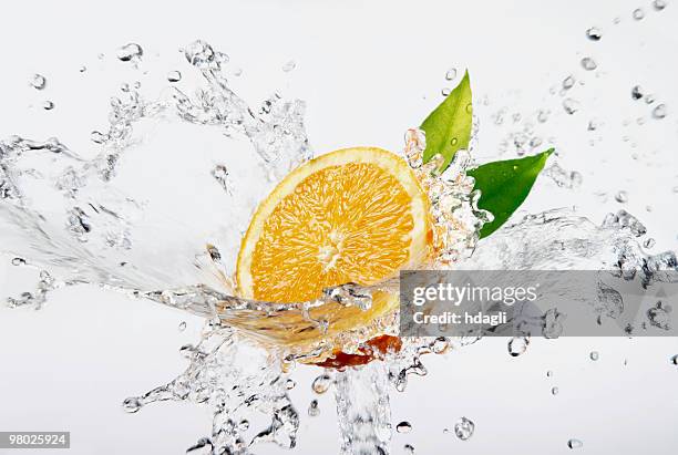 frische orange - splashed water leaf stock-fotos und bilder