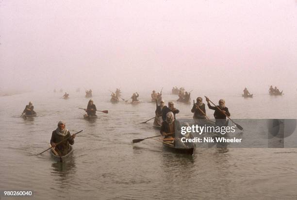 Marsh Arab men paddle in small boats to fishing grounds in the wetlands of Southern Iraq where Tigris and Euphrates rivers meet circa 1978.