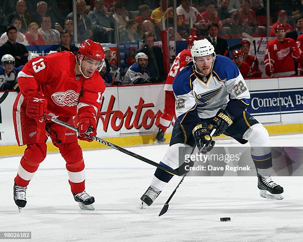 Brad Boyes of the St. Louis Blues and Pavel Datsyuk of the Detroit Red Wings battle for the loose puck during an NHL game at Joe Louis Arena on March...