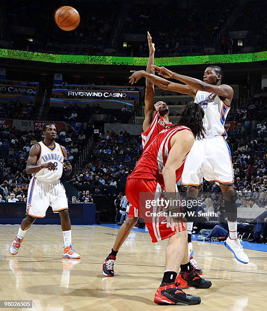 Kevin Durant of the Oklahoma City Thunder passes the ball over Trevor Ariza and Luis Scola of the Houston Rockets during the game at the Ford Center...