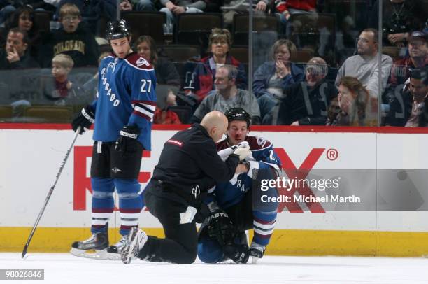 Scott Hannan of the Colorado Avalanche is tended to after being hit in the face with a stick by the Los Angeles Kings player at the Pepsi Center on...