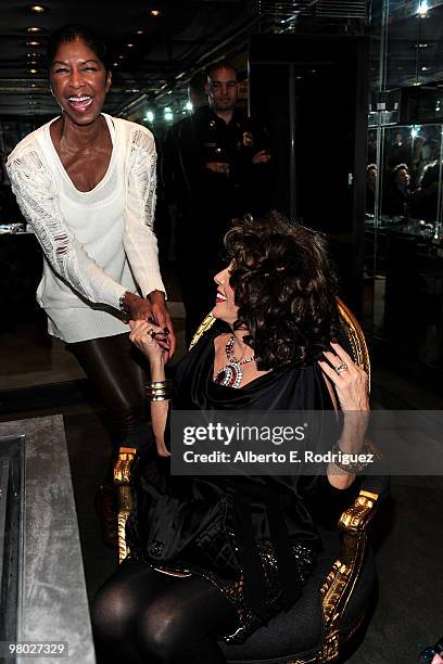 Singer Natalie Cole and actress Joan Collins try on jewelry at 'A Parisian Afternoon' hosted by The House of Lloyd Klein Couture on March 24, 2010 in...