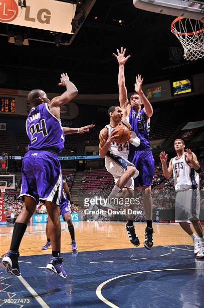 Devin Harris of the New Jersey Nets shoots against Carl Landry and Spencer Hawes of the Sacramento Kings during the game on March 24, 2010 at the...