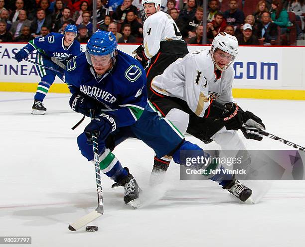 Michael Grabner of the Vancouver Canucks skates with the puck as Lubomir Visnovsky of the Anaheim Ducks looks on during their game at General Motors...