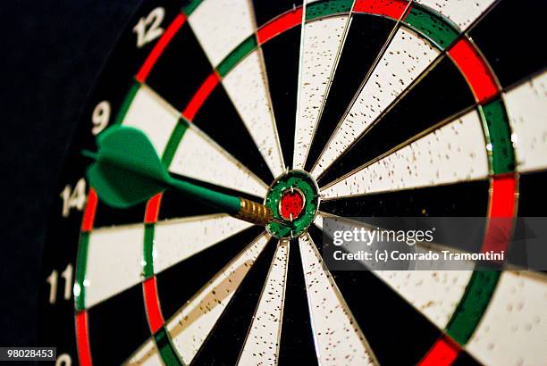 dart in target bull's-eye  - cible de jeu de fléchettes photos et images de collection