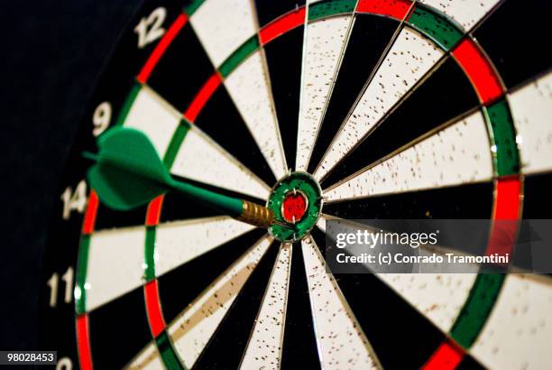 dart in target bull's-eye - dartboard stock pictures, royalty-free photos & images