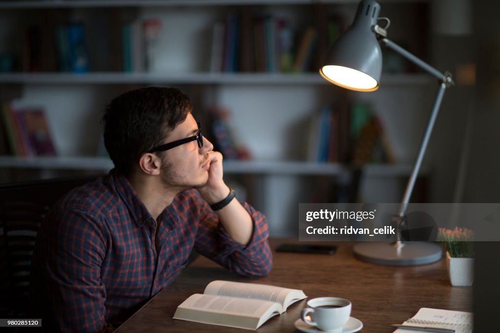 Mann liest Buch auf dem Tisch