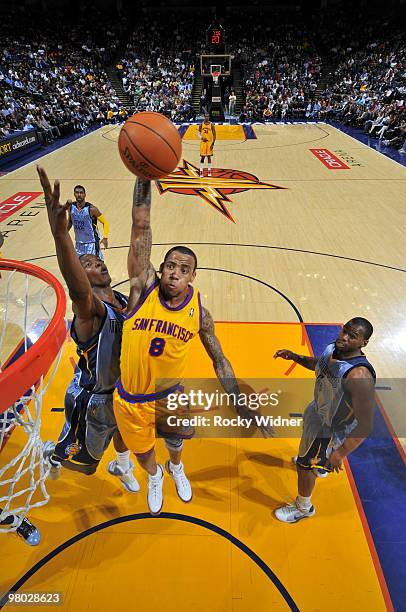 Monta Ellis of the Golden State Warriors soars through the air for a dunk against Darrell Arthur and Sam Young of the Memphis Grizzlies on March 24,...