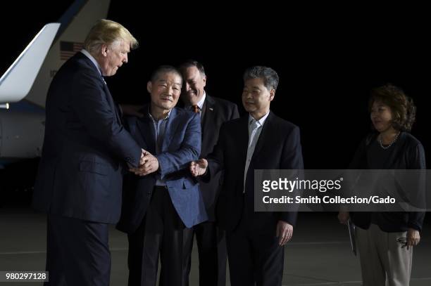 Nighttime photograph of President Donald Trump greeting three Americans returning from imprisonment in North Korea, Joint Base Andrews, Maryland, May...