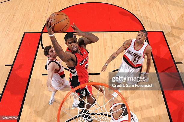 Amir Johnson of the Toronto Raptors shoots a layup against Juwan Howard, Rudy Fernandez and Marcus Camby of the Portland Trail Blazers during the...