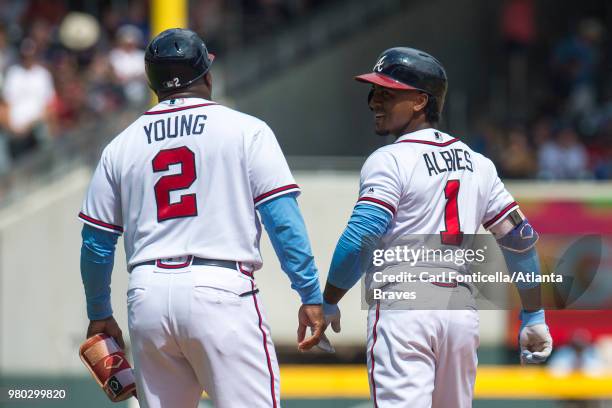 Ozzie Albies of the Atlanta Braves talks to first base coach Eric Young after getting on second base against the San Diego Padres at SunTrust Park on...