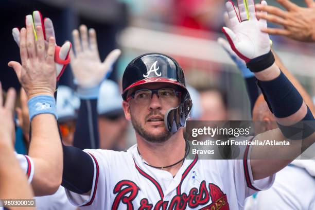 Tyler Flowers of the Atlanta Braves celebrates in the dugout after scoring against the San Diego Padres at SunTrust Park on June 17 in Atlanta,...