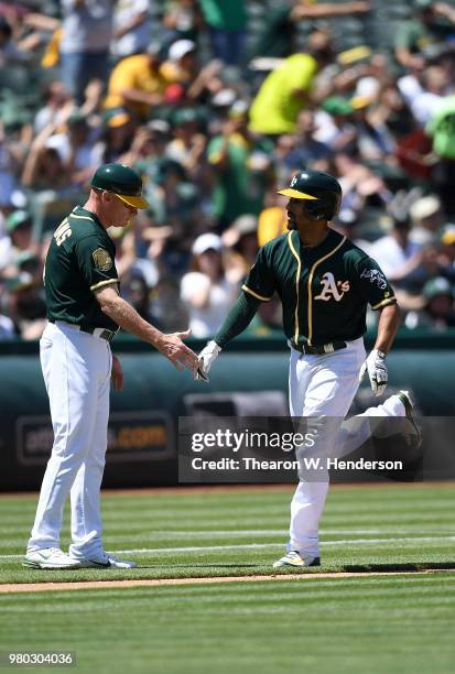 Marcus Semien of the Oakland Athletics is congratulated by third base coach Matt Williams after Semien hit a solo home run against the Los Angeles...