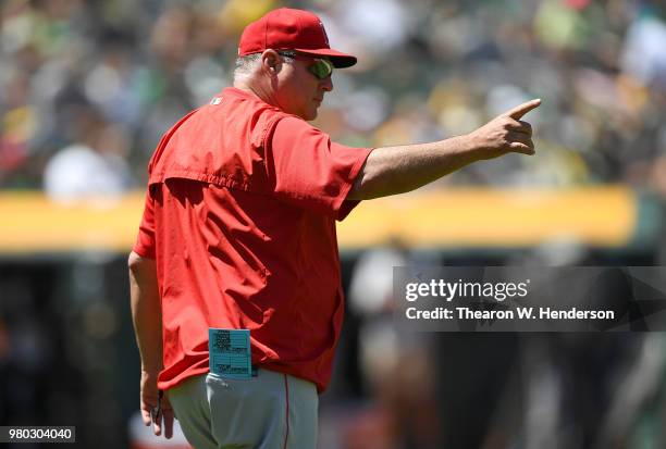 Manager Mike Scioscia of the Los Angeles Angels of Anaheim signals the bullpen to make a pitching change against the Oakland Athletics in the bottom...