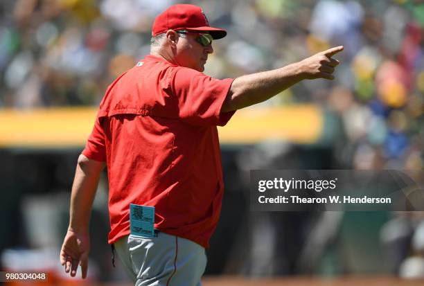 Manager Mike Scioscia of the Los Angeles Angels of Anaheim signals the bullpen to make a pitching change against the Oakland Athletics in the bottom...