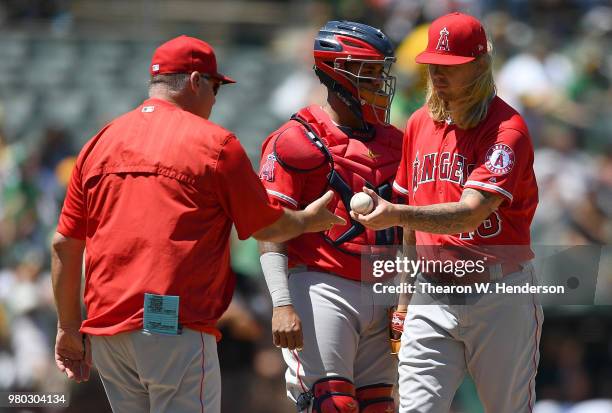 Manager Mike Scioscia of the Los Angeles Angels takes the ball from starting pitcher John Lamb making a pitching change against the Oakland Athletics...