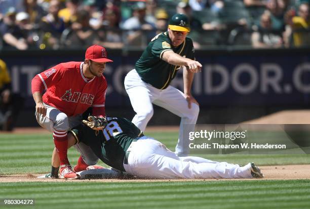 Chad Pinder of the Oakland Athletics dives into third base with a triple ahead of the throw to David Fletcher of the Los Angeles Angels of Anaheim as...