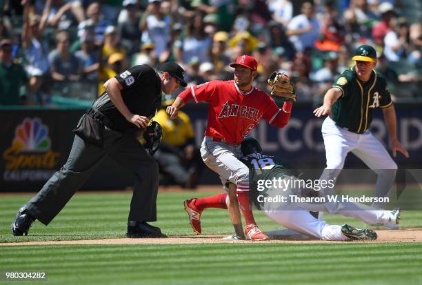 Chad Pinder of the Oakland Athletics dives into third base with a triple ahead of the throw to David Fletcher of the Los Angeles Angels of Anaheim as...