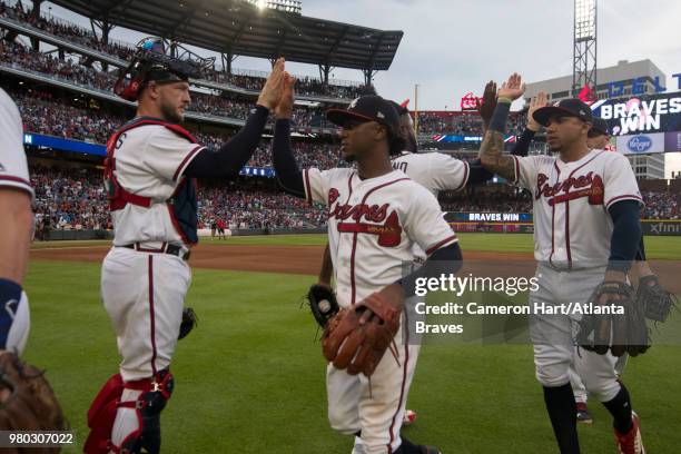 Tyler Flowers, Ozzie Albies, and Johan Camargo of the Atlanta Braves shake hands following the game against the San Diego Padres at SunTrust Park on...