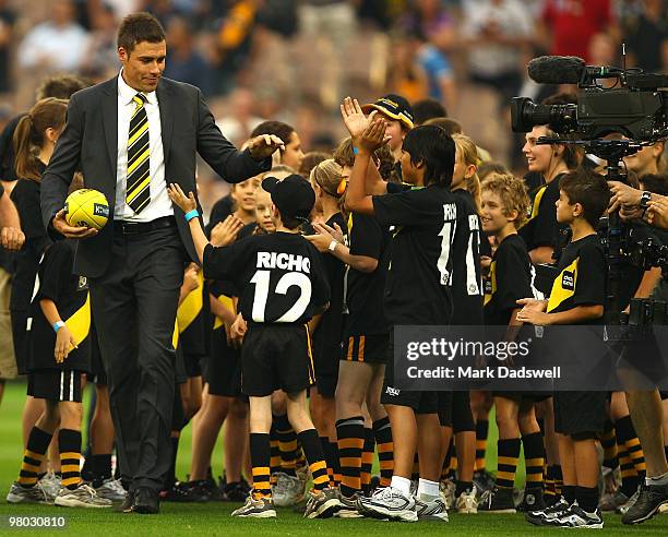 Former Club champion Matthew Richardson is greeted by a guard of honour of children wearing the club jumper with his name and number before the round...