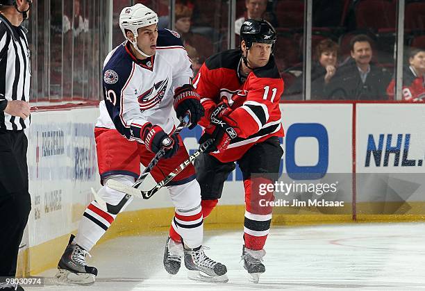 Jared Boll of the Columbus Blue Jackets skates against Dean McAmmond of the New Jersey Devils at the Prudential Center on March 23, 2010 in Newark,...